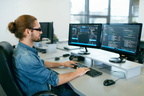 Symbolbild für Informationstechnologie: Mann arbeitet am Computer