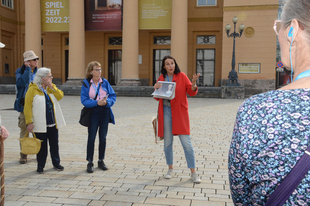Reiseleiterin Antonella Placheta mit einer Reisegruppe vor dem Tiroler Landestheater